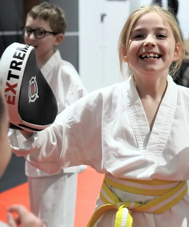 Smiling young girl in karate gi training at Limitless kids martial arts class in Southampton